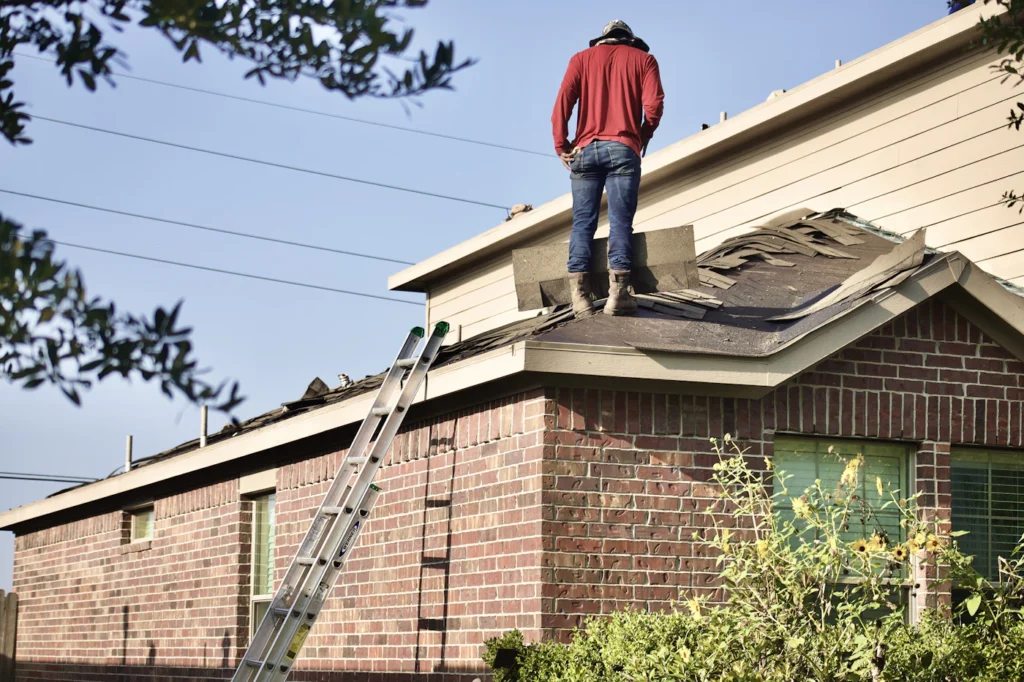 Roofer assessing a roof on a brick house