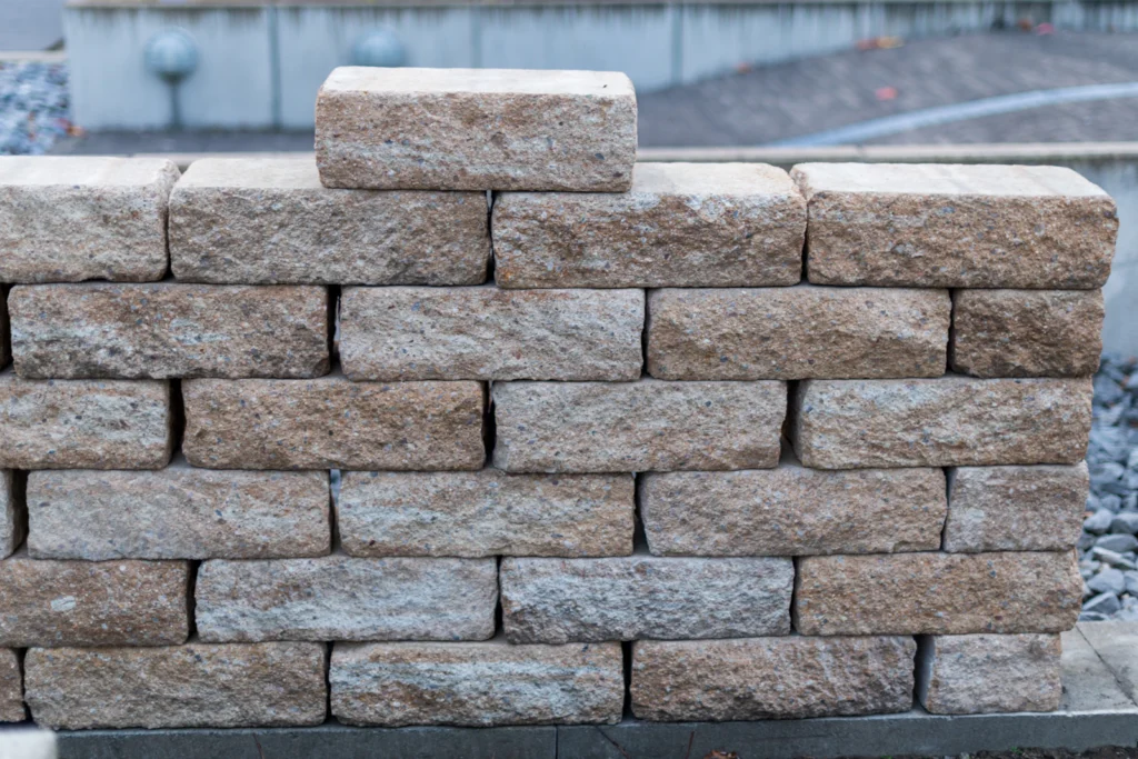 Stone block retaining wall along a landscaped yard